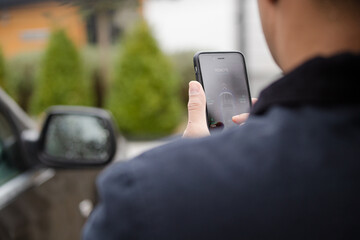 Personal perspective man setting car alarm from smart phone
