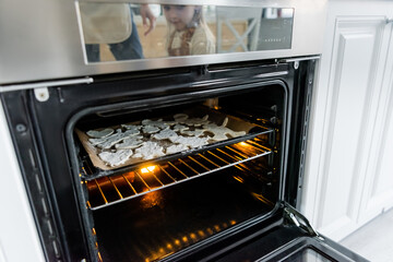 baking sheet with multi shaped cookies in electric oven