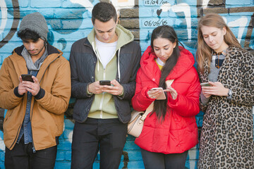 Young adult friends using smart phones