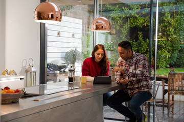 Couple financial planning at digital tablet in kitchen