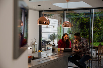 Couple financial planning at digital tablet in kitchen