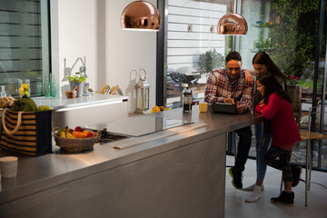 Family using digital tablet at kitchen table