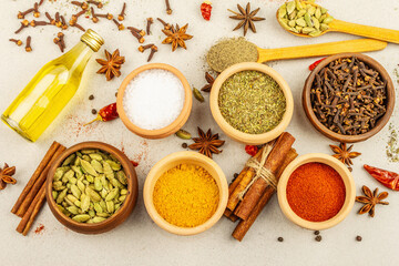 A set of spices for cooking curry. Aromatic condiments on light stone concrete background