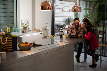 Family using digital tablet at kitchen table