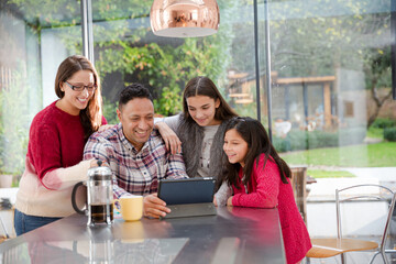 Happy family planning vacation at digital tablet in kitchen