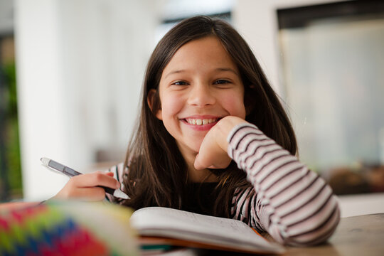 Portrait confident, smiling girl doing homework