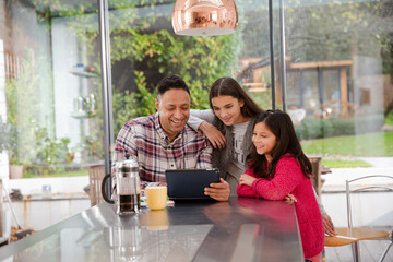 Happy family planning vacation at digital tablet in kitchen