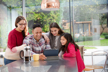 Happy family planning vacation at digital tablet in kitchen