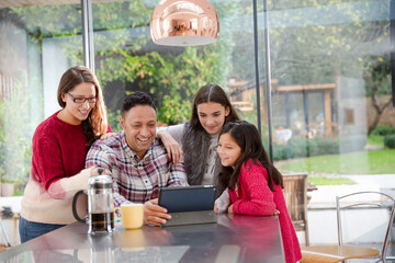 Happy family planning vacation at digital tablet in kitchen