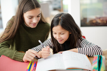 Obraz premium Girl helping young sister with homework