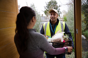 Woman greeting food deliveryman at front door