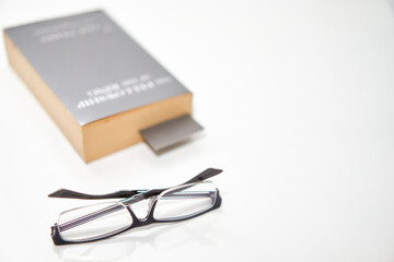 read glasses selective focus on blur Bookmark in old book on white background high angle view