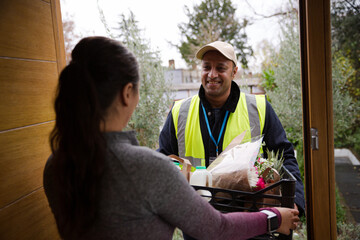 Woman greeting food deliveryman at front door