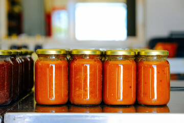 Closeup of fresh quince marmalade in jars on table at factory