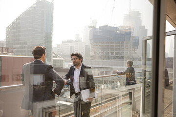 Fototapeta premium Two businessmen talking on balcony