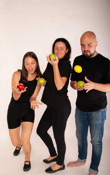 a family with apples in their hands portray funny theatergoers vegetarians for a healthy image of life against meat. The concept of weight loss