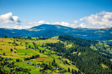 Naklejka na ściany i meble view from the top of the mountain to the village.Carpathians morning landscape. High quality photo