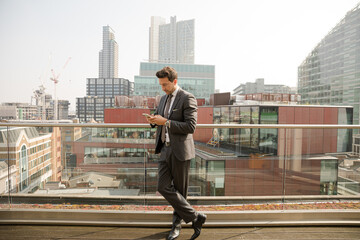 Businessman using smarpthone on balcony