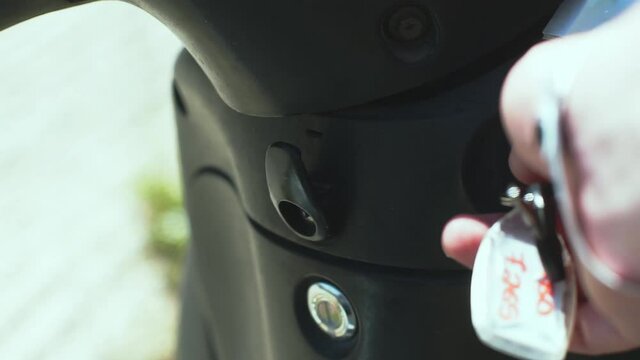 Turning the key in an Ignition lock of an motor scooter to start it