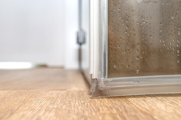 Seals in the lower part of the thresholdless shower enclosure, visible door corner..