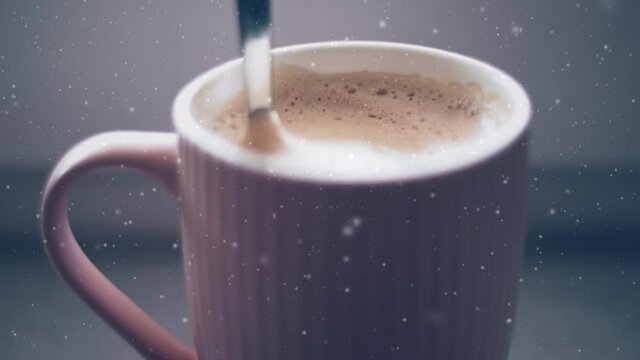 Mug with latte coffee at home in winter, snow and Christmas glitter and relaxing cosy mood. High quality FullHD footage