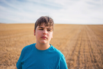 portrait of a boy in a dry field