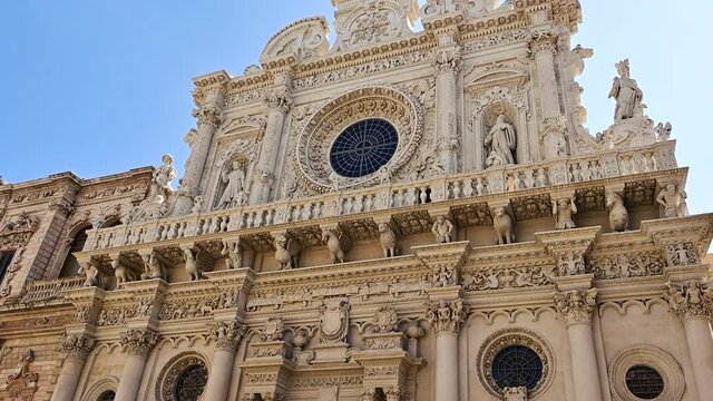 Lecce, Puglia, Italy. August 2021. The Basilica of Santa Croce is the finest example of the Lecce Baroque. The tilt footage highlights the richness of the facade details. Beautiful summer day.