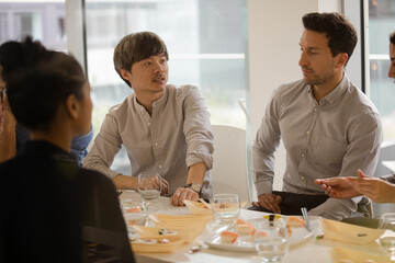 Business people eating sushi lunch in conference room