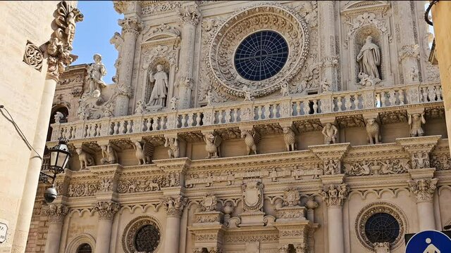 Lecce, Puglia, Italy. August 2021. The Basilica of Santa Croce is the finest example of the Lecce Baroque. The tilt footage highlights the richness of the facade details. Beautiful summer day.