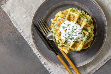 Homemade zucchini waffles in a plate on a culinary background top view