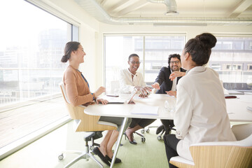 Happy business people touching hands, celebrating success in conference room