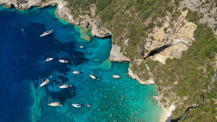 Aerial drone photo of sail boats anchored in tropical Caribbean island paradise bay with white rock...