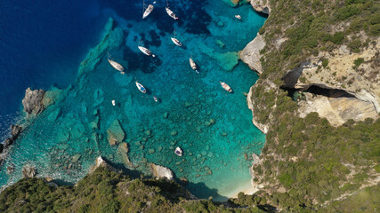 Aerial drone photo of tropical rocky paradise bay called blue caves with turquoise clear sea visited by sail boats and yachts, island of Paxos, Ionian, Greece