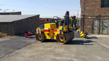 A skating rink for laying asphalt for road construction. A skating rink compacting the asphalt on the track. Asphalting the territory. Landscaping of the territory and streets. Construction equipment.