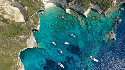 Aerial drone photo of tropical rocky paradise bay called blue caves with turquoise clear sea visited by sail boats and yachts, island of Paxos, Ionian, Greece