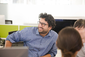 Business people meeting at computer in open plan office