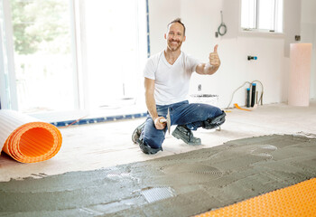 Man worker install orange roll membrane waterproofing on the floor