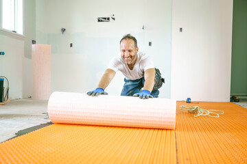 Man worker install orange roll membrane waterproofing on the floor