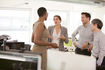 Business people talking in open plan office