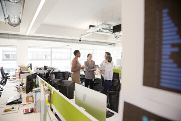 Business people talking in open plan office