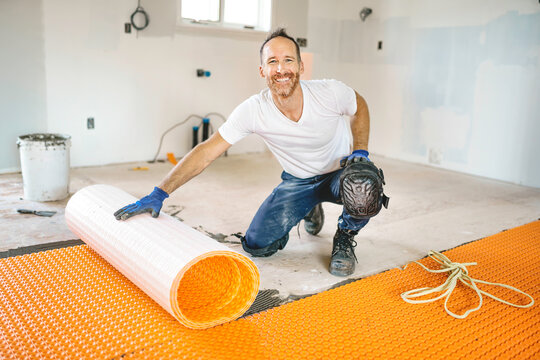 Man worker install orange roll membrane waterproofing on the floor