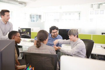 Business people meeting at computer in open plan office