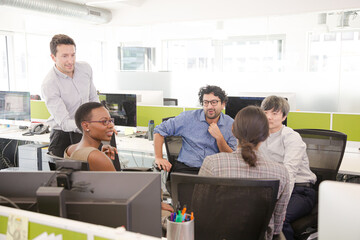 Business people meeting at computer in open plan office