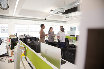 Business people talking in open plan office