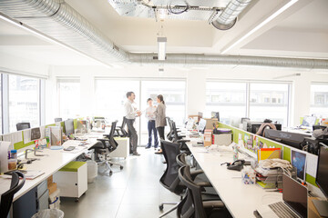 Business people talking in open plan office