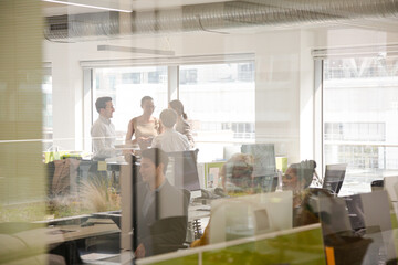 Business people talking in open plan office