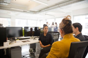 Business people talking in open plan office