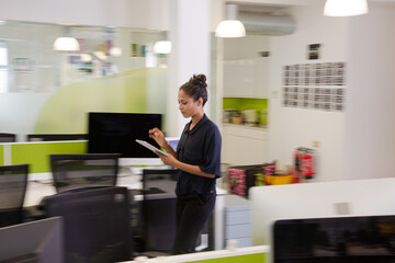 Businesswoman using tablet computer in open plan office