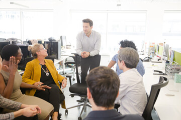 Business people meeting at computer in open plan office