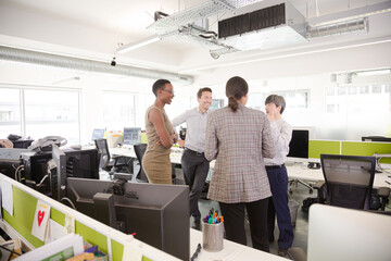 Business people talking in open plan office